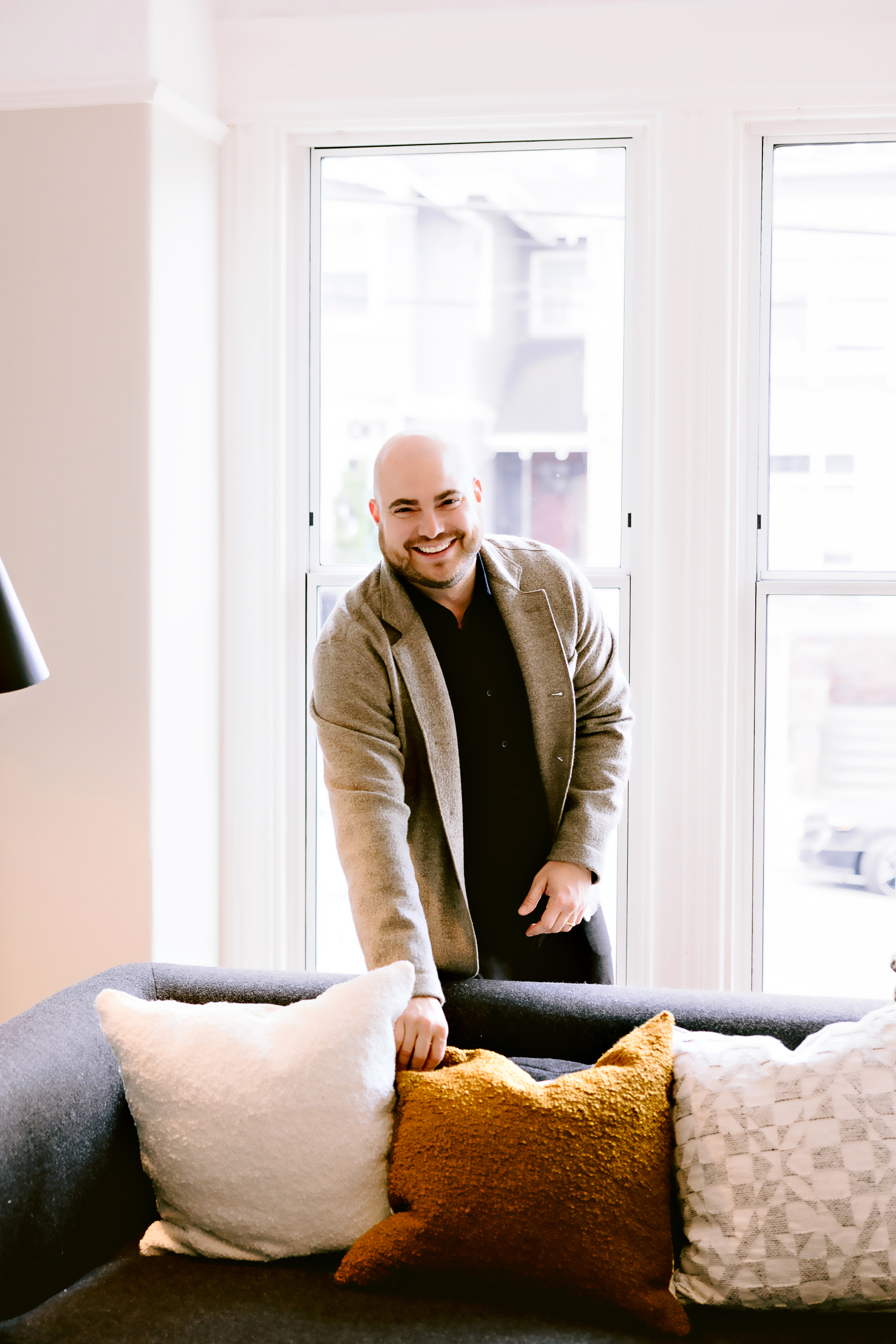 Daniel Souza arranging pillows in a living room